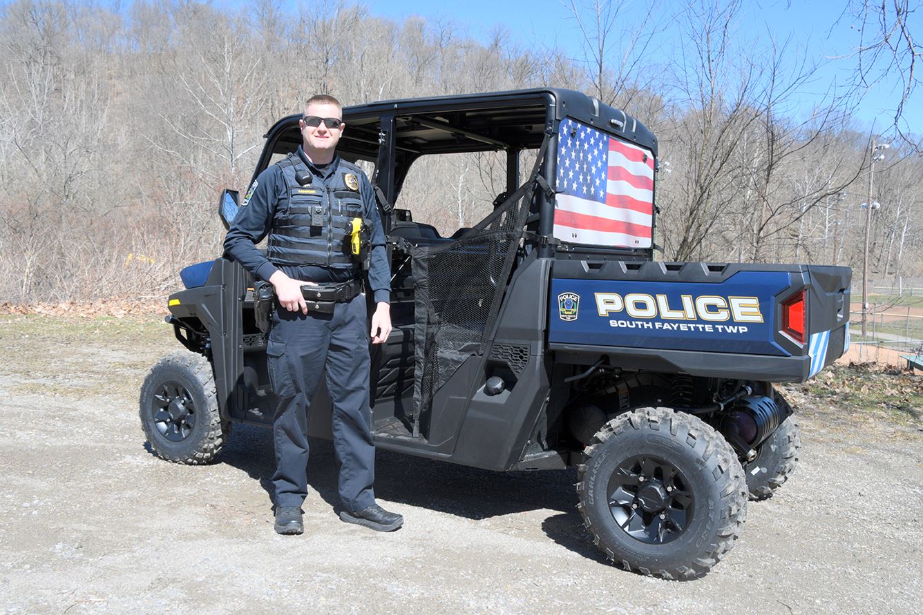 Police Lt stands outdoors with utility terrain vehicle
