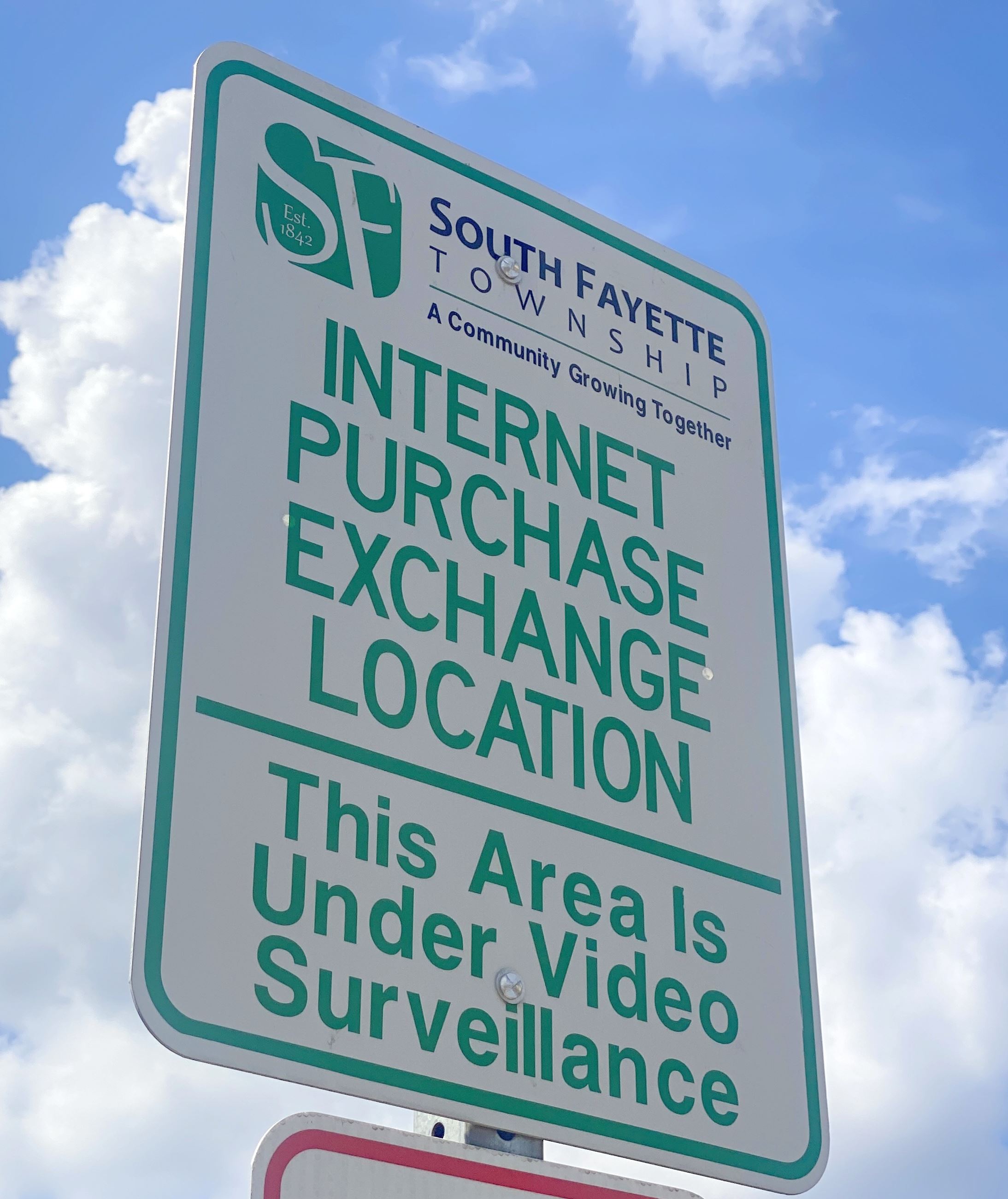 Internet Purchase Exchange Location sign in green text with township logo and sky background IMG_777