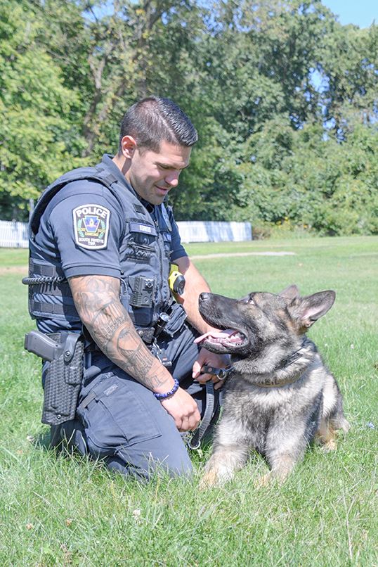 Officer Korkus and K9 Oneil in grass looking at each other